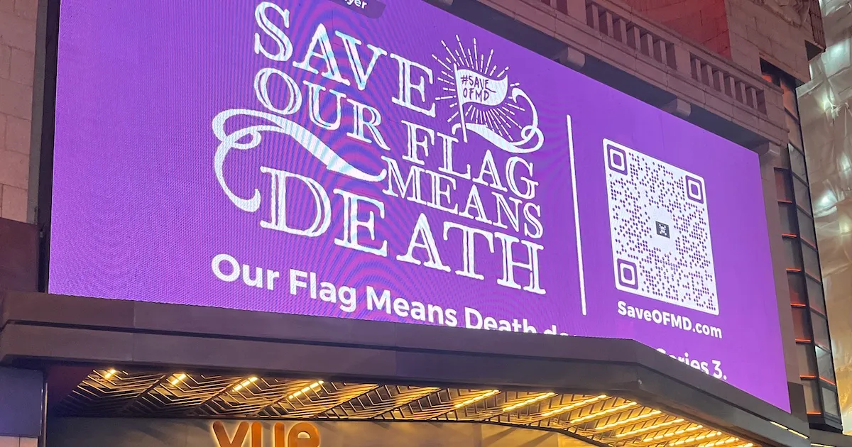 A purple billboard reading "Save Our Flag Means Death," with a QR code to the right.