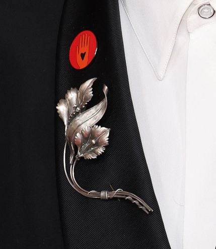 Close up of a red circular pin on Mark Ruffalo's lapel.