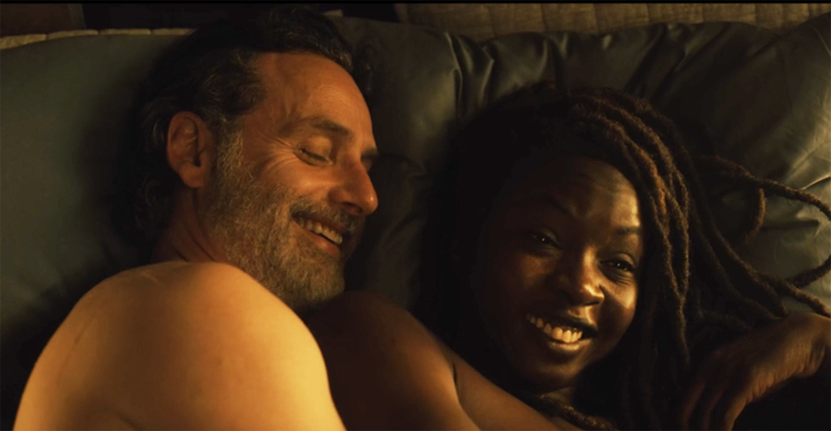 rick grimes and michonne lying in bed together, smiling