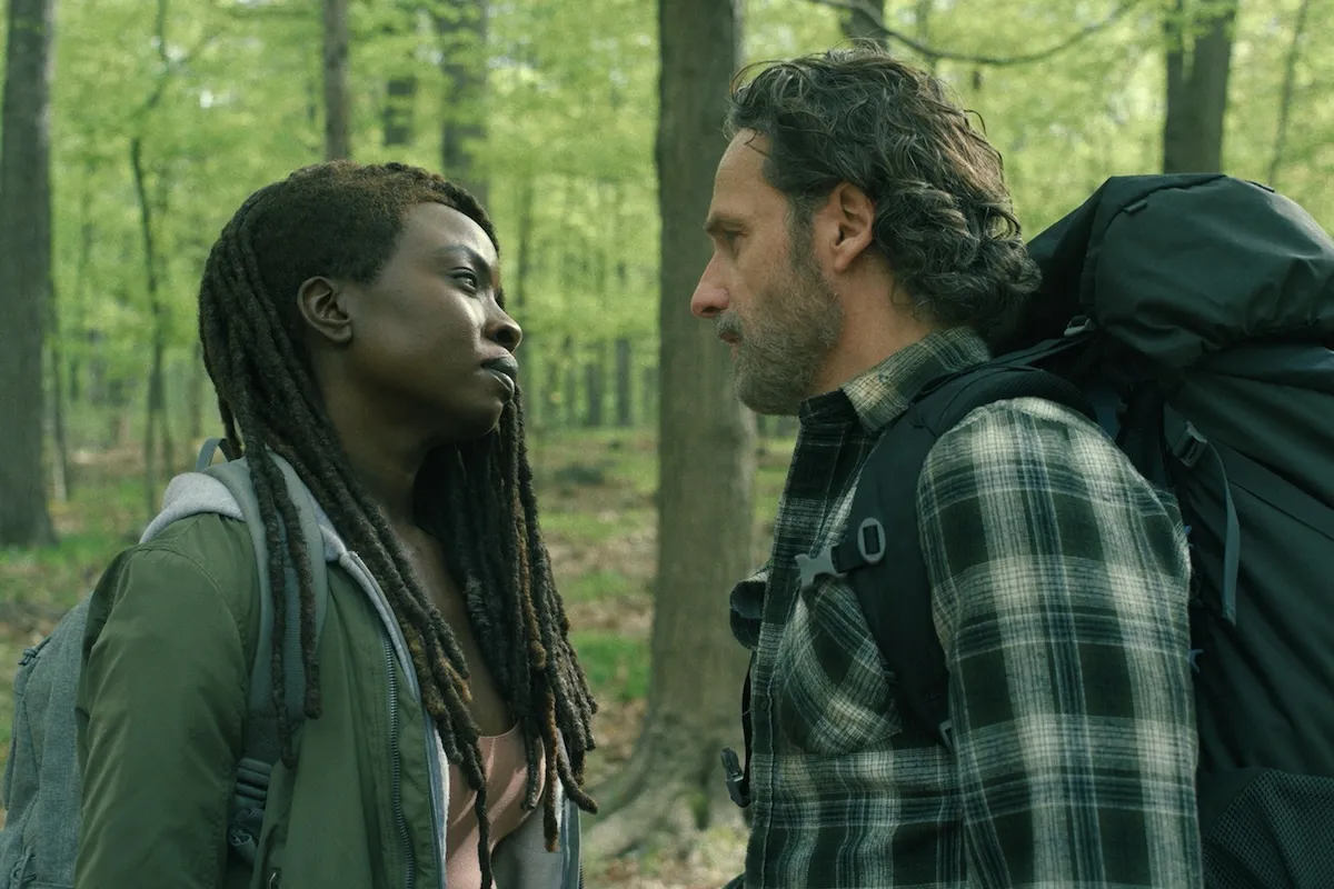 Rick and Michonne standing in the woods with each other