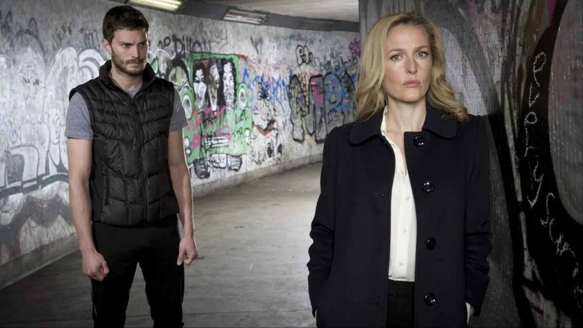 Jamie Dornan stand behind Gillian Anderson in a subway station in 'The Fall'.