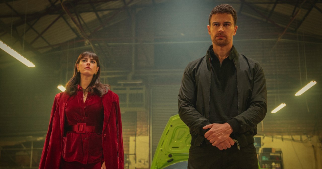 Susie Glass (Kaya Scodelario) and Eddie Horniman (Theo James) stand in a warehouse.