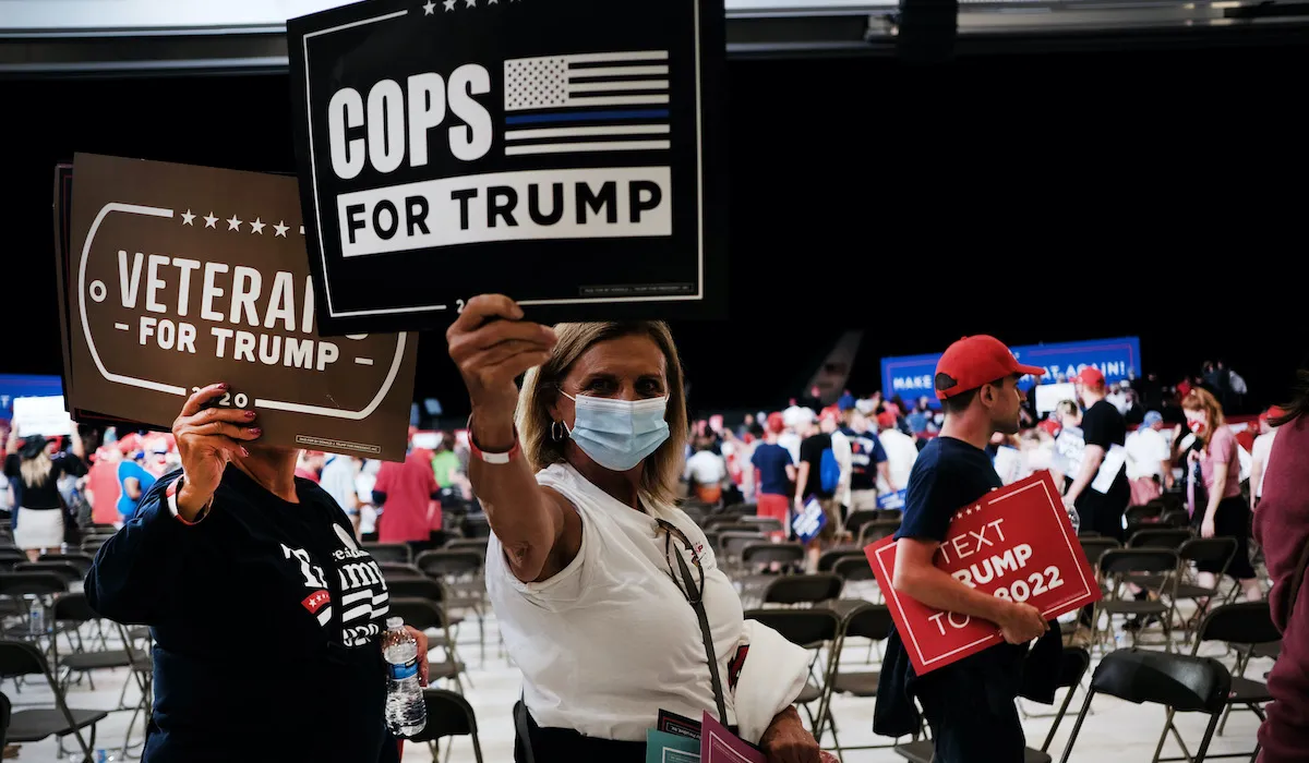 Attendees of the RNC in 2020 hold signs supporting Trump.