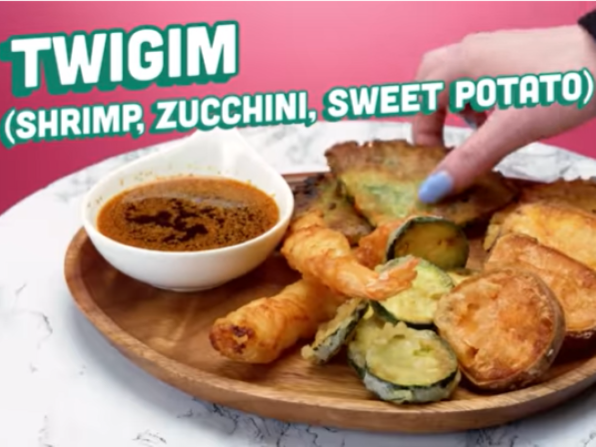 Screenshot from the Wee Bear Bares 2 Try Not to Eat video on People vs Food. Battered shrimp and vegetables on a wooden plate, and soy sauce n a white dish.