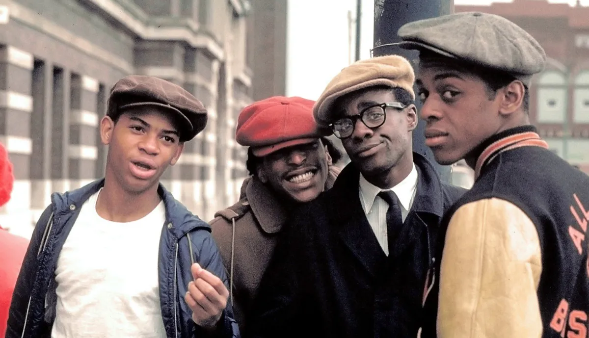 a group of high school boys stand on the street and smile into the camera in "Cooley High"
