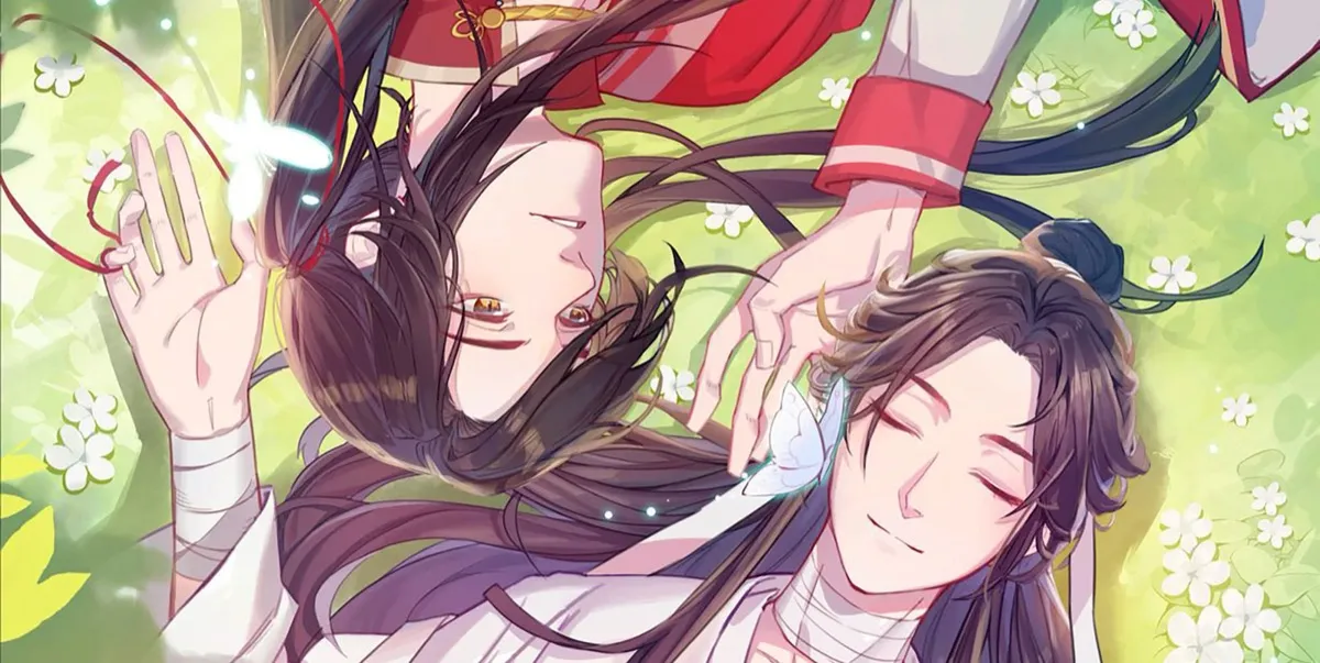 Two handsome boys laying in the grass head to head in "Heaven's Official Blessing"