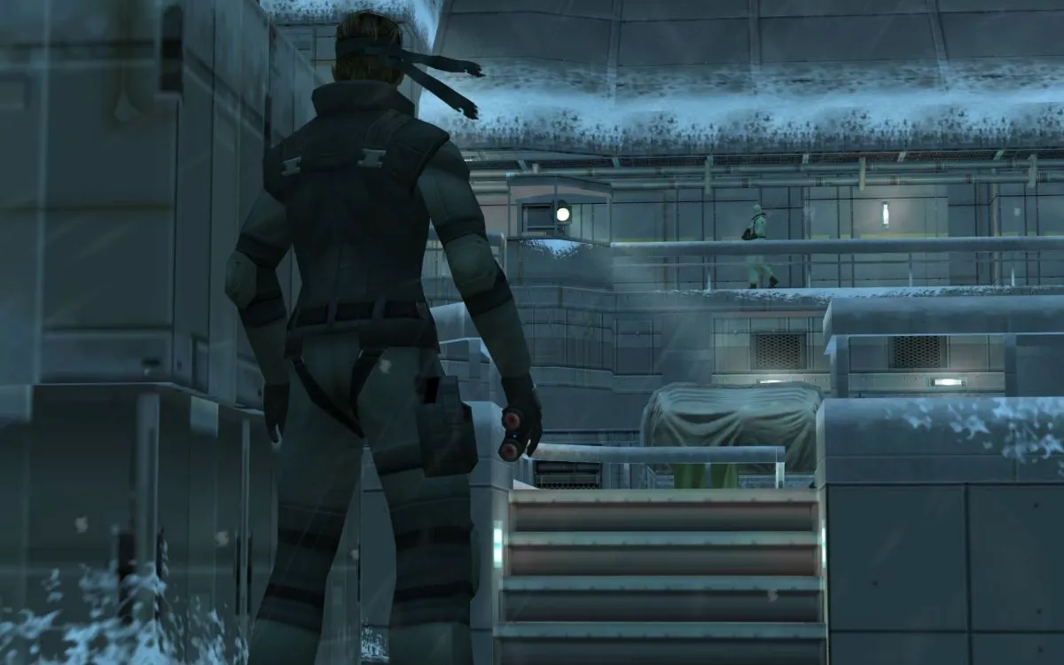 Solid Snake stands inside a snow covered military base in "Metal Gear Solid"