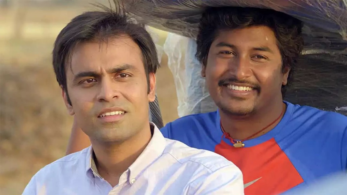 A man looks confused while another smiles in "Panchayat" 