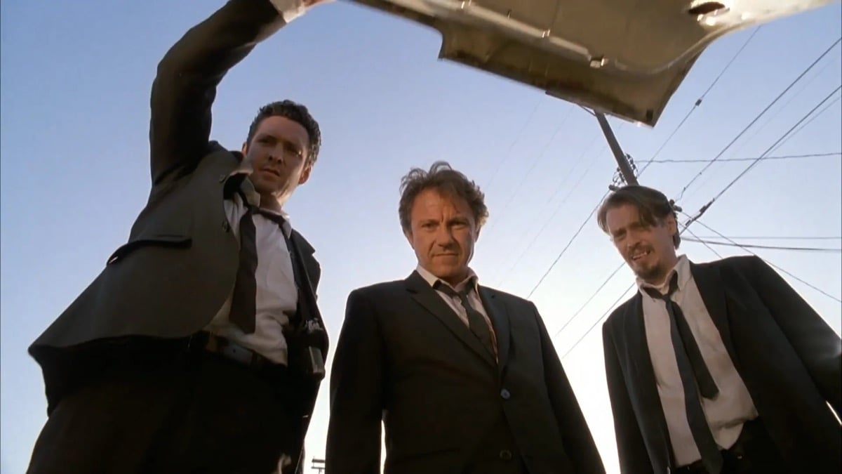 Three men in suits peer into the trunk of a car in "Reservoir Dogs"