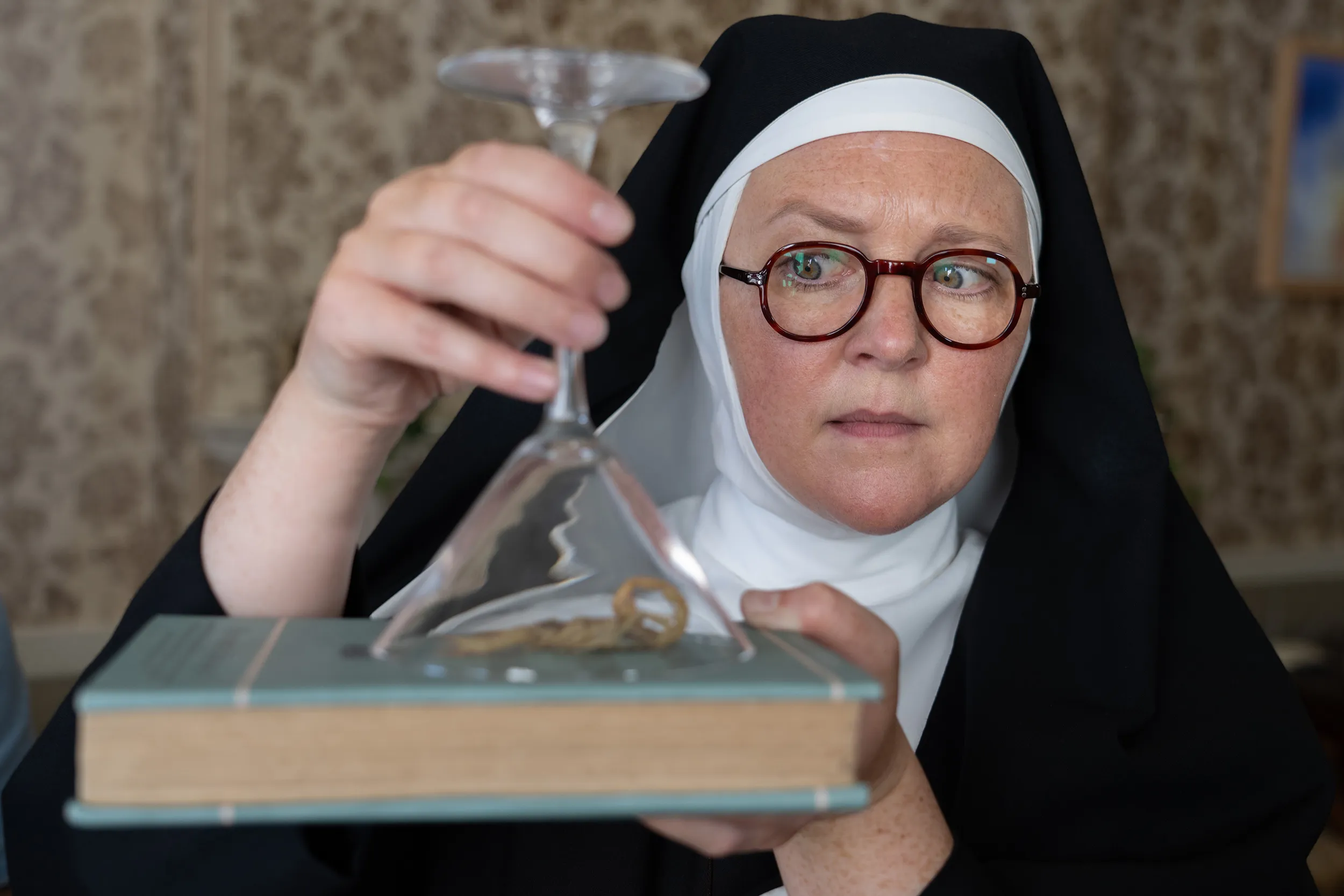 Lorna Watson as Sister Boniface, holding up a book in Sister Boniface Mysteries season 3