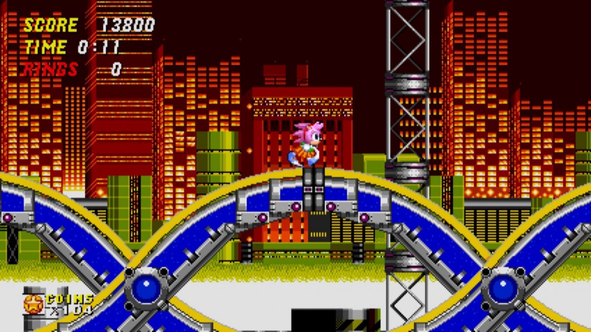 A pink hedgehog runs through a 2D city in "Sonic Origins Plus"