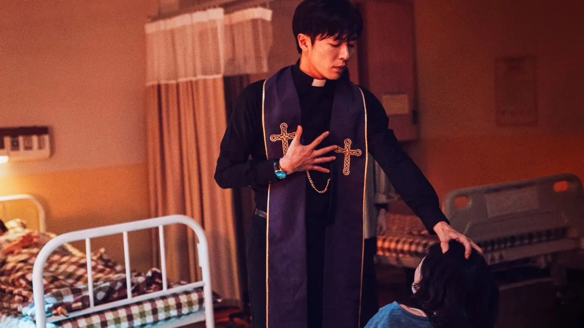 A boy in a priest outfit performs a bedroom exorcism in "The Guest" 