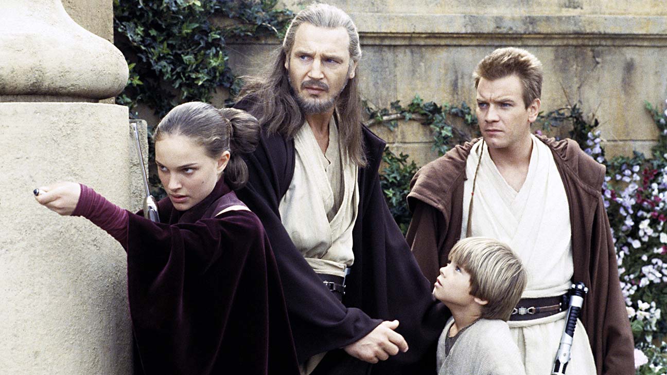 Shown from left: Natalie Portman (as Queen Padmé Amidala), Liam Neeson (as Qui-Gon Jinn), Jake Lloyd (as Anakin Skywalker), Ewan McGregor (as Obi-Wan Kenobi) all stand together.