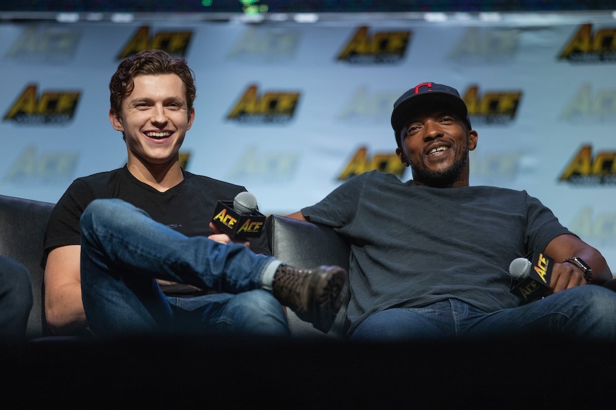 Anthony Mackie and Tom Holland laughing on a couch at a convention