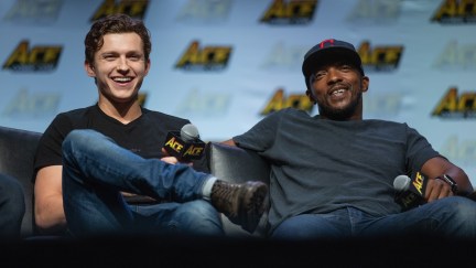 Anthony Mackie and Tom Holland laughing on a couch at a convention