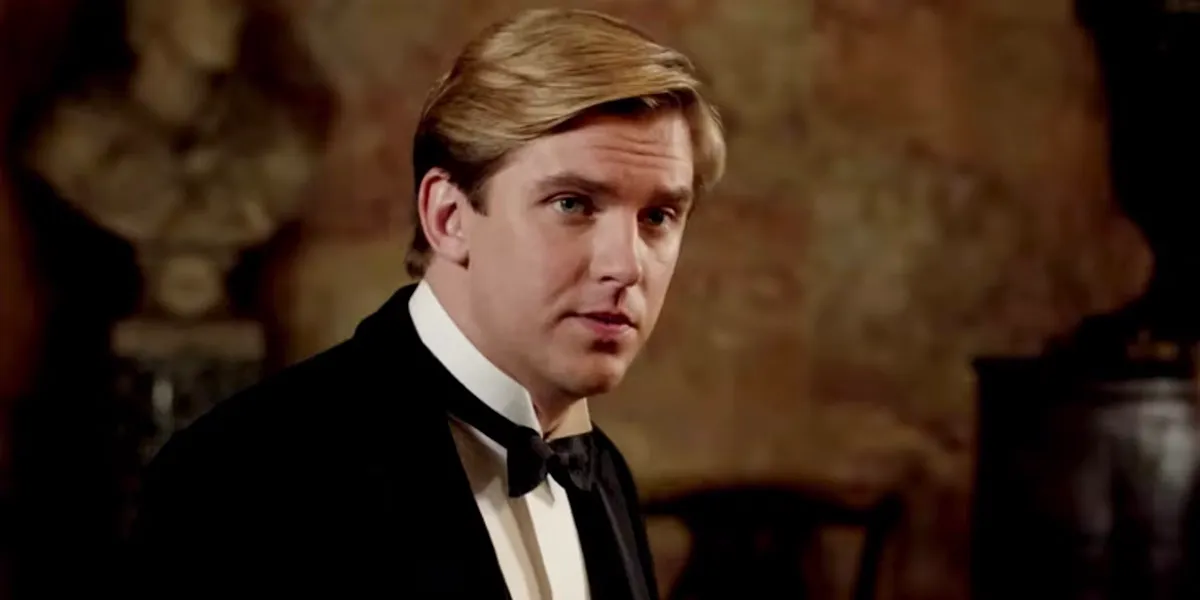 dan stevens in a suit looking at someone in downton abbey