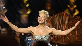 Hannah Waddingham with her arms raised while on stage