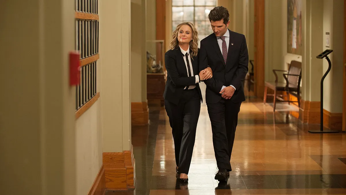 ben and leslie walking arm in arm down the hallway in parks and recreation