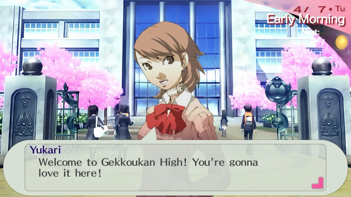 A schoolgirl talks outside the school while cherry blossoms bloom in "Persona 3 Portable"