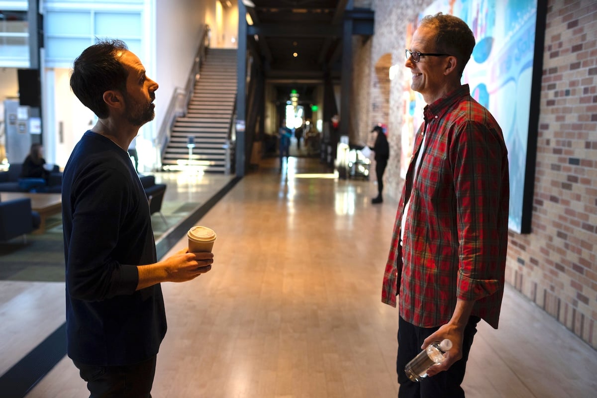 Kelsey Mann and Pete Docter standing in a hallway talking at Pixar