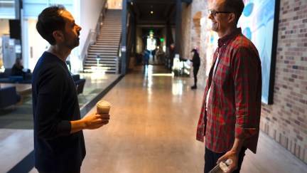 Kelsey Mann and Pete Docter standing in a hallway talking at Pixar