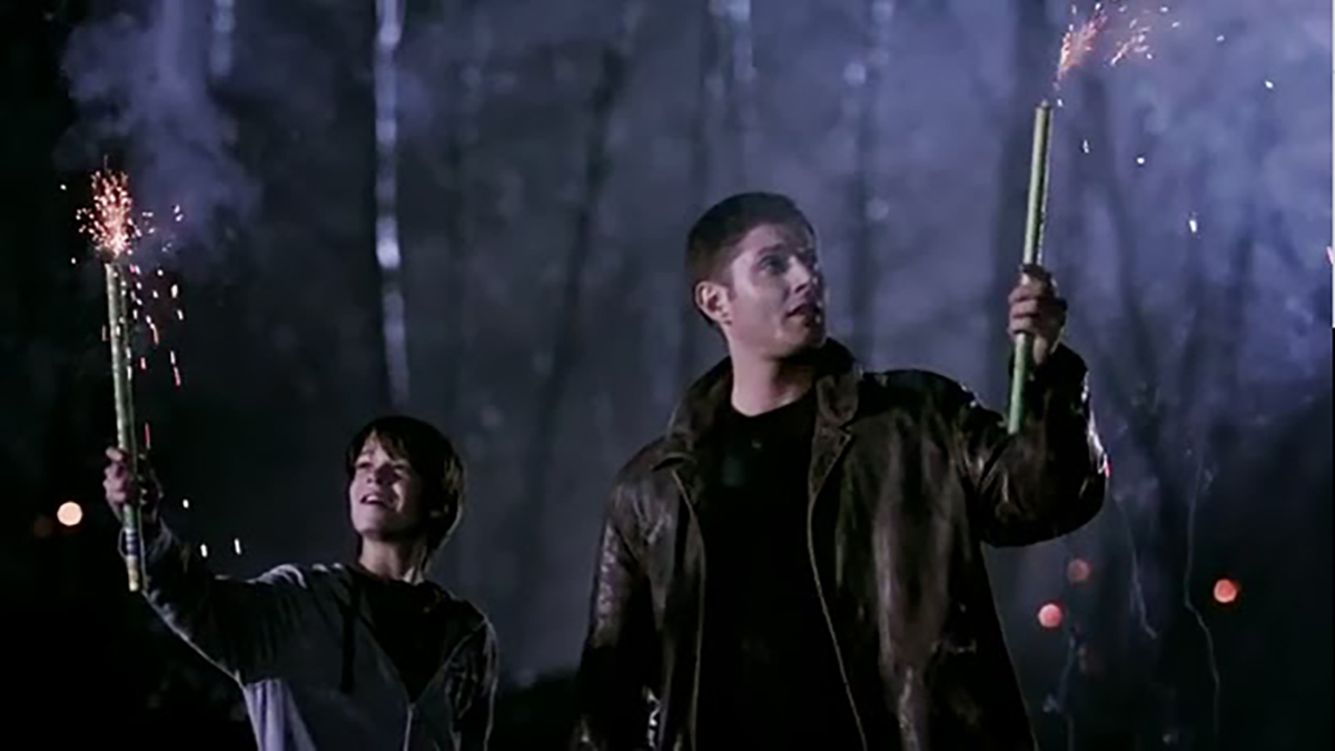 Dean and a child holding sparklers in Supernatural
