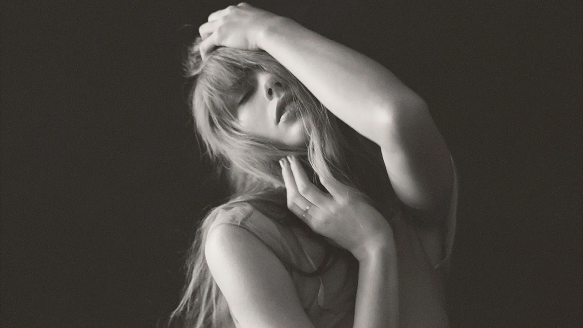 taylor swift with her head in her hands and posing for the tortured poets department