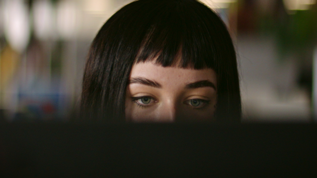 A woman's face is half-hidden by her computer screen in a still from 'Ashley Madison: Sex, Lies & Scandal'