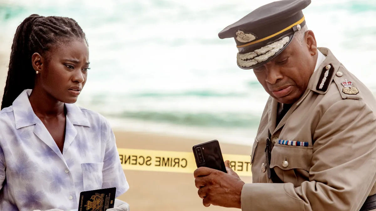 Shantol Jackson and Don Warrington in Death in Paradise, standing by a crime scene on the beach