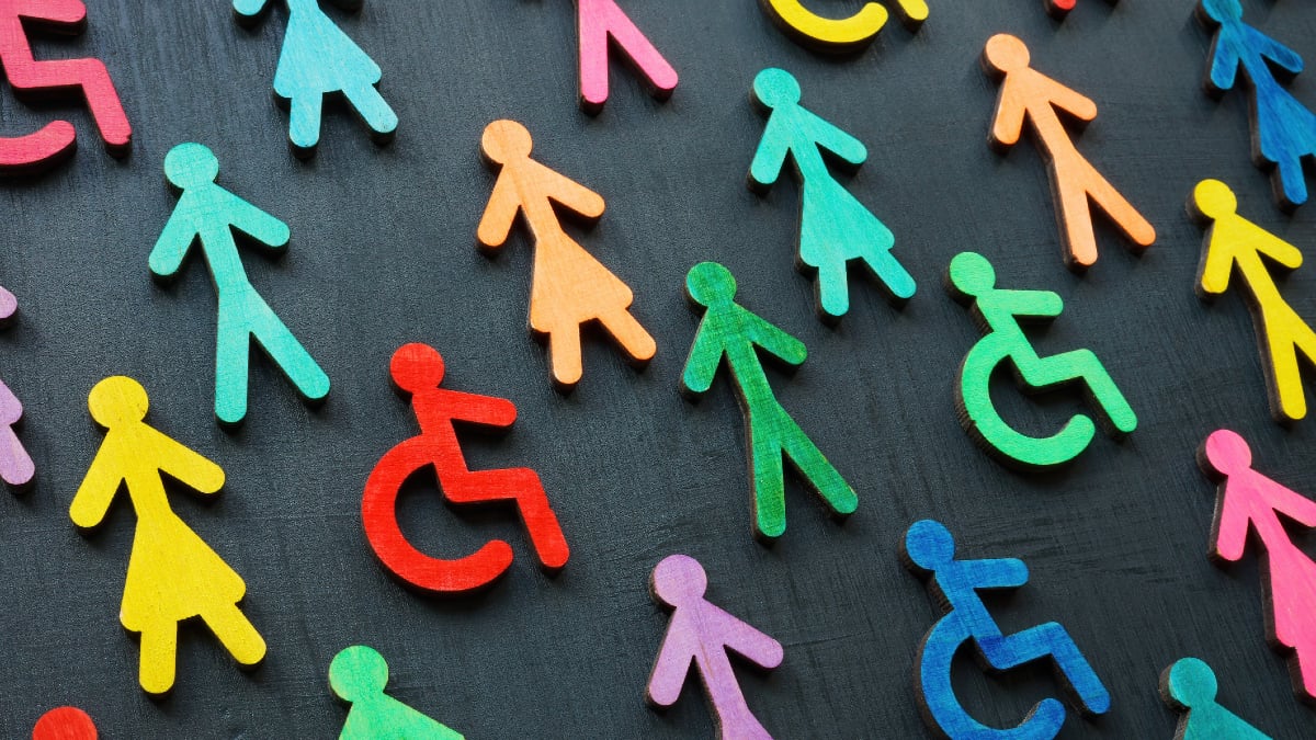 Colorful stick figures and disability symbols together on a dark background