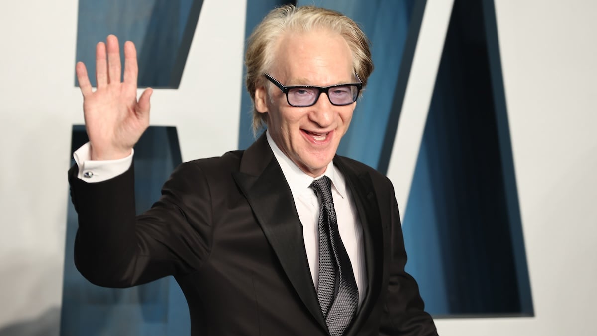 Bill Maher waves on a red carpet