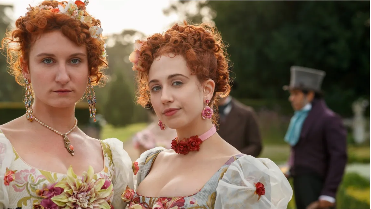 (L to R) BESSIE CARTER as PRUDENCE FEATHERINGTON and HARRIET CAINS as PHILLIPA FEATHERINGTON in episode 106 of BRIDGERTON
