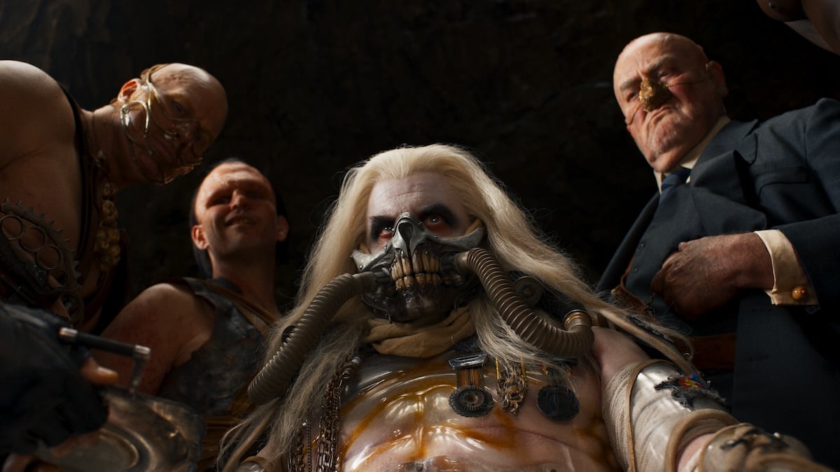 Immortan Joe stares down at the camera, surrounded by his sons and henchmen.