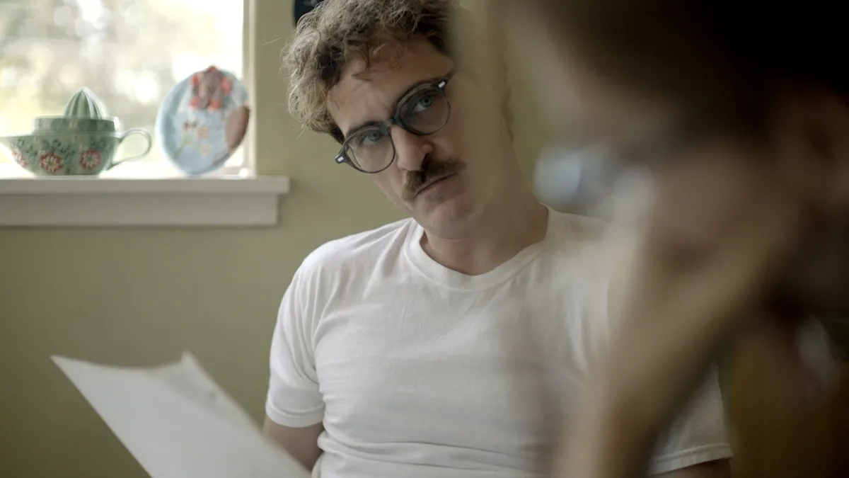 joaquin phoenix wearing glasses with a mustache in her