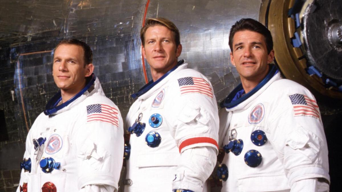 Three astronauts stand smiling in space suits in "From Earth To The Moon"