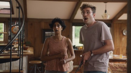 A hipster couple look flabbergasted in a cabin in 