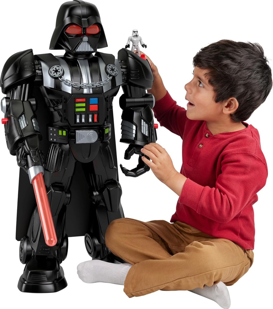 Little kid sitting next to a 2-foot-tall Darth Vader robot