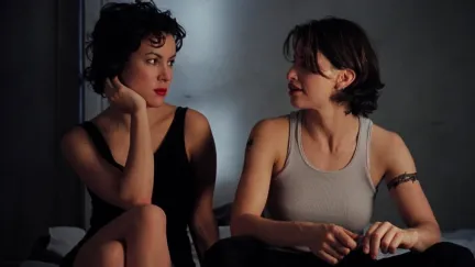 Two beautiful women make eyes at each other while sitting in 