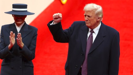 First lady Melania Trump and U.S. President Donald Trump backdropped by a red carpet, arrive during an indoor inauguration parade at the Capital One Arena