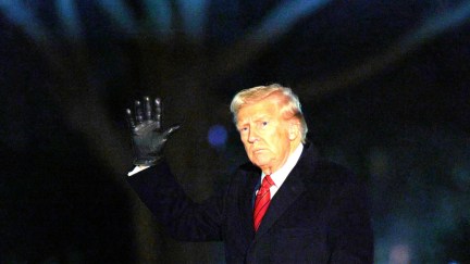 Donald Trump waves to reporters while entering the White House