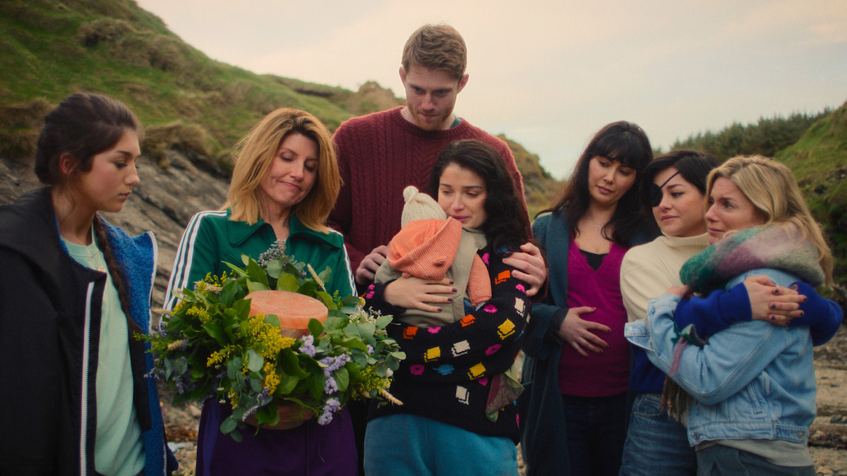 The cast of Bad Sisters in the 'Bad Sisters' season 2 finale, holding flowers in the countryside