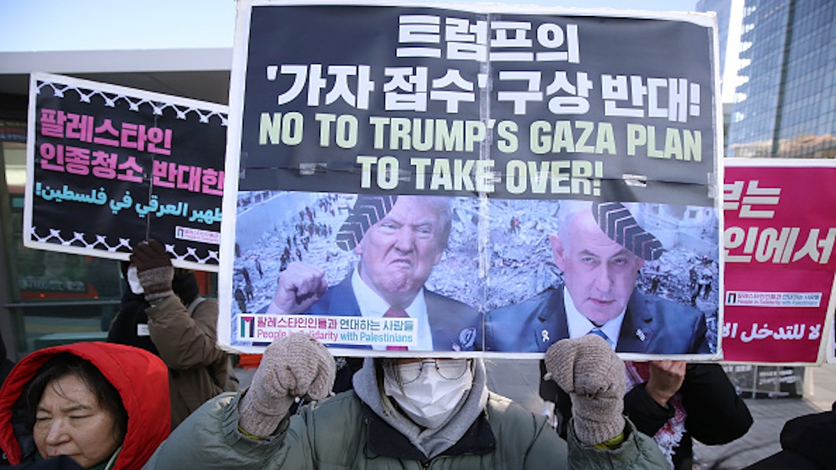 Protestors hold up signs in opposition to Trump's Gaza takeover plan