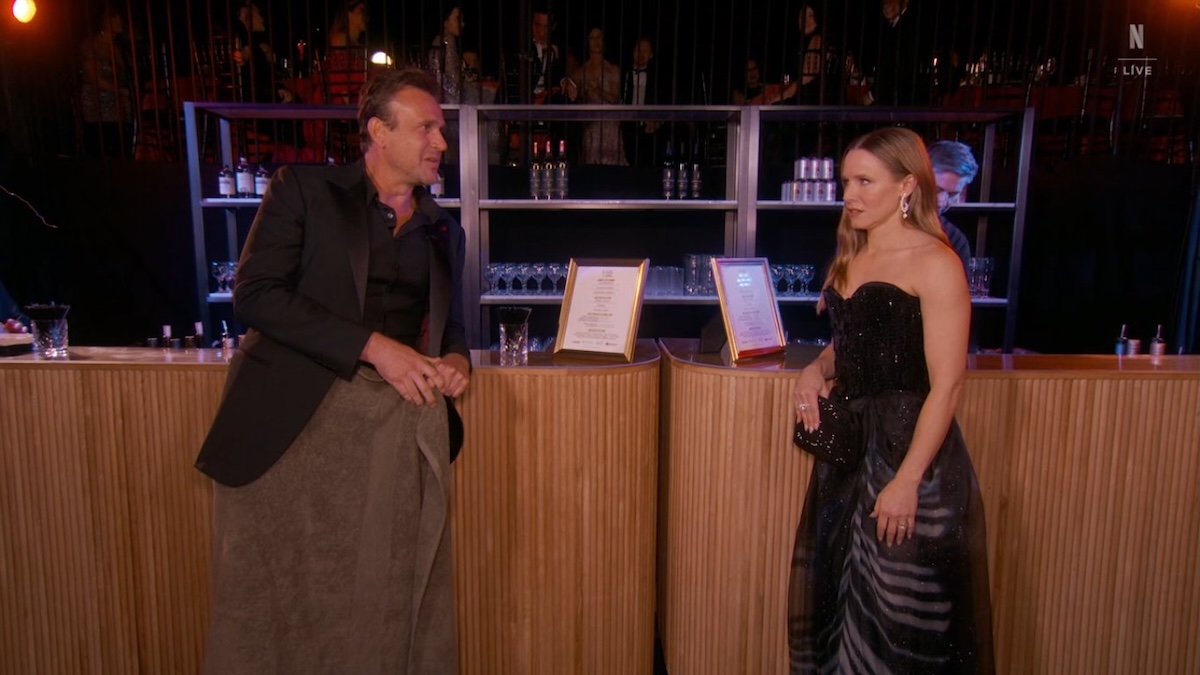 jason segel and kristen bell standing together at a bar