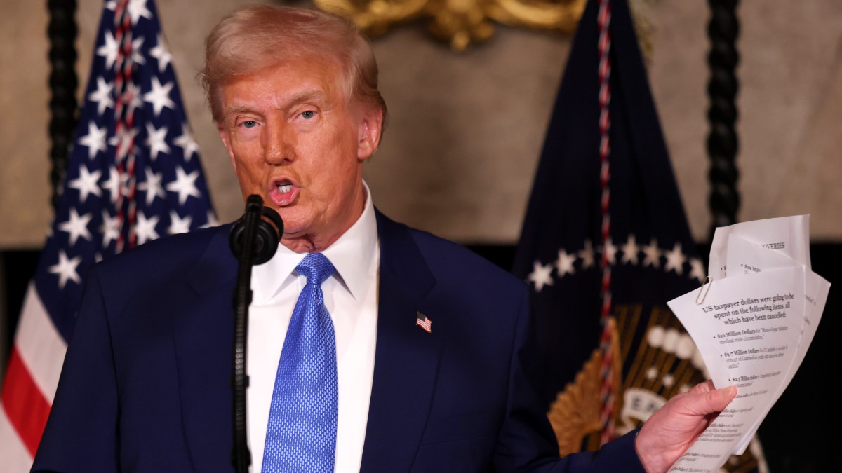 Donald Trump holds up executive orders at Mar-a-Lago