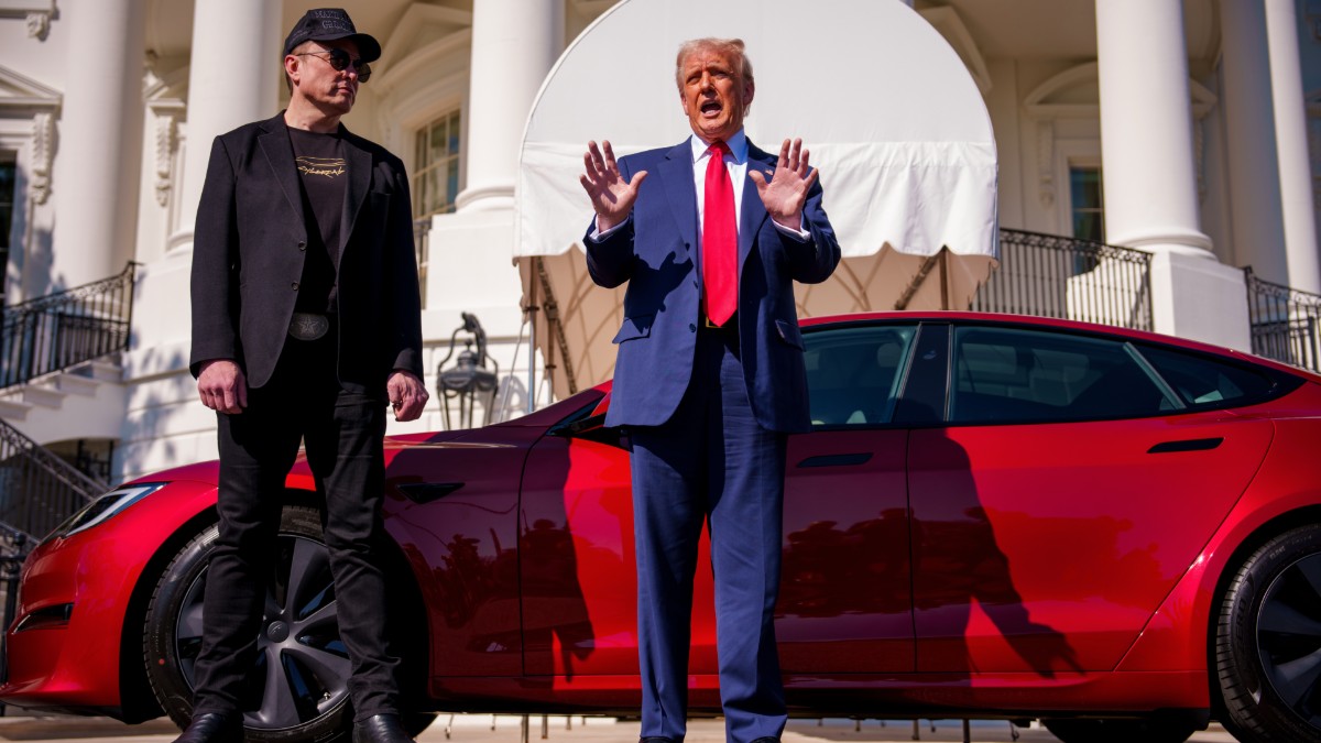 Elon Musk and Donald Trump stand outside a Tesla parked in front of the White House
