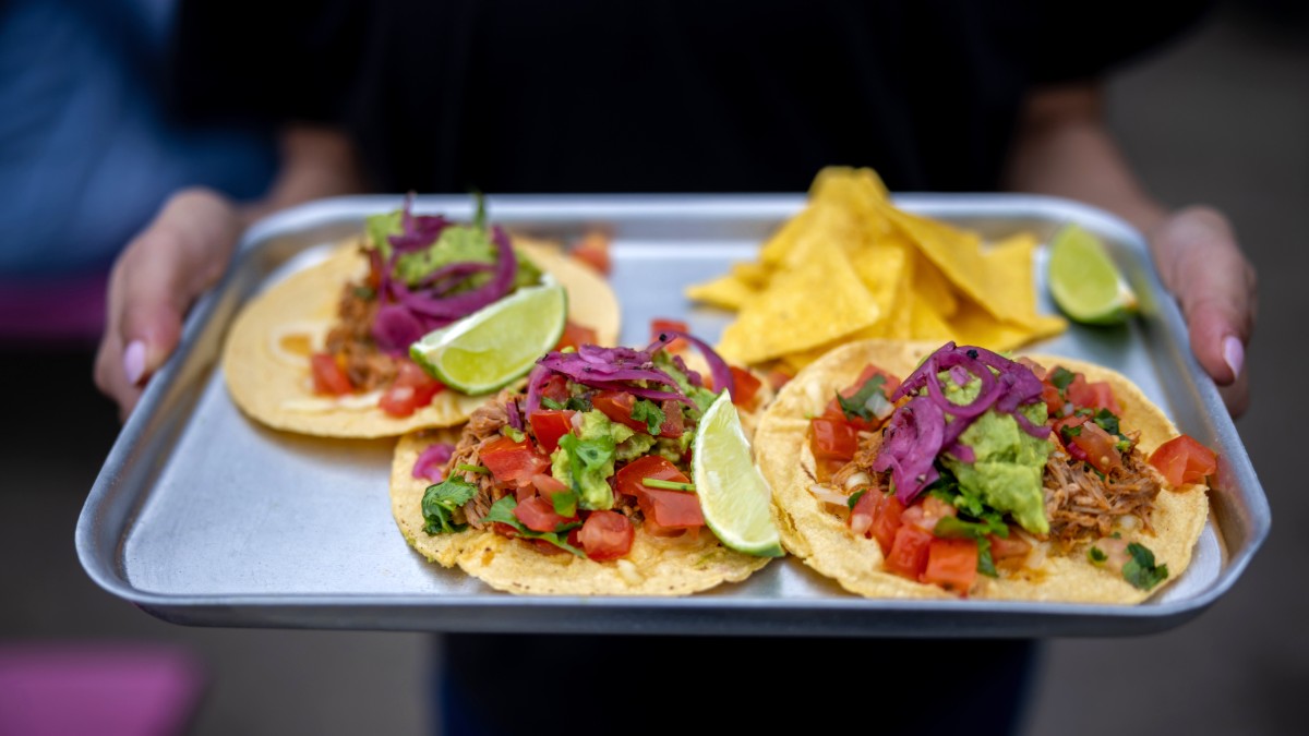 A waiter holds a tray of food at a Mexican restaurant