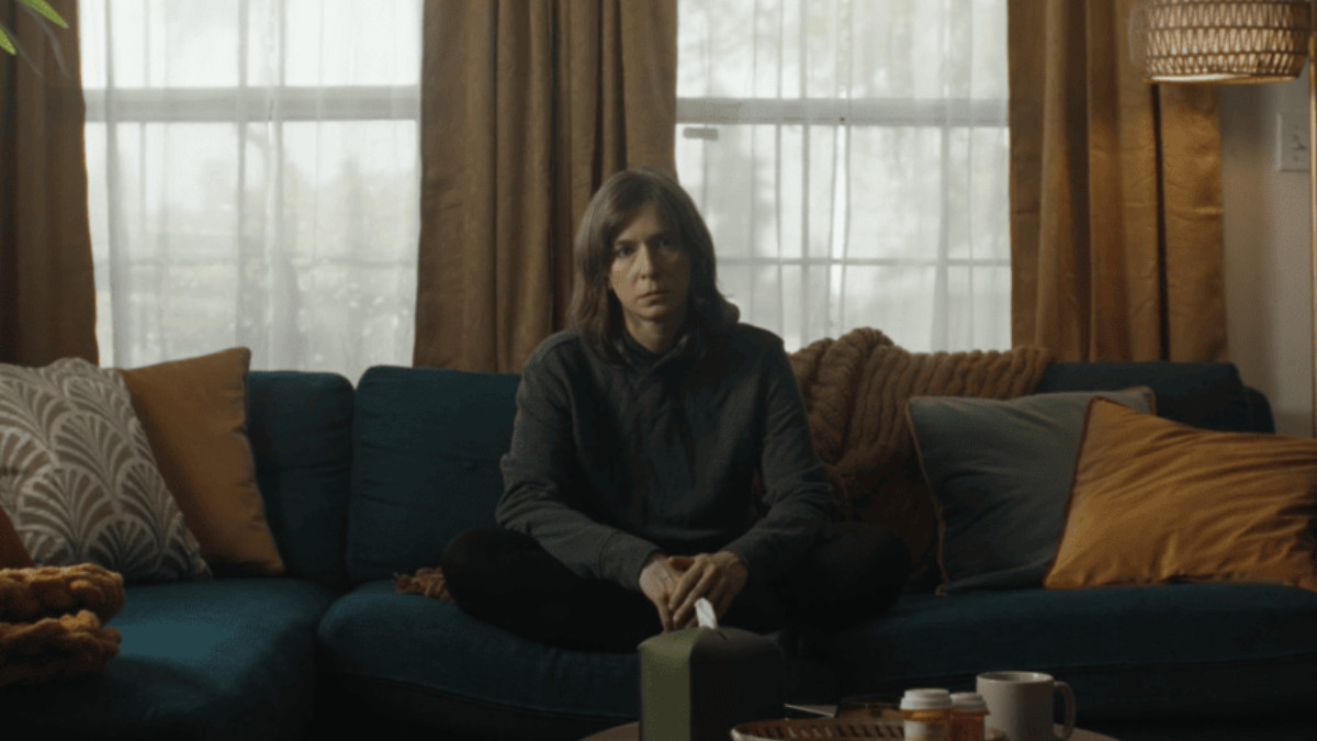 Deanna Rooney sits on a sofa in 'Out for Delivery'