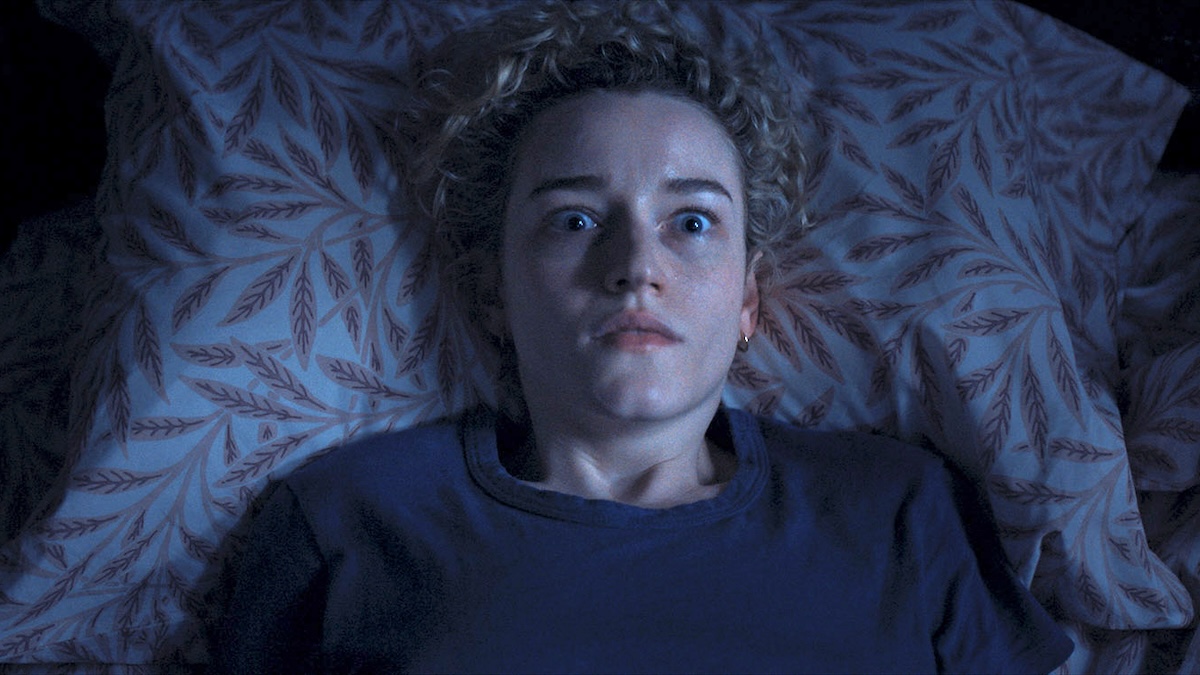 julia garner laying in a bed