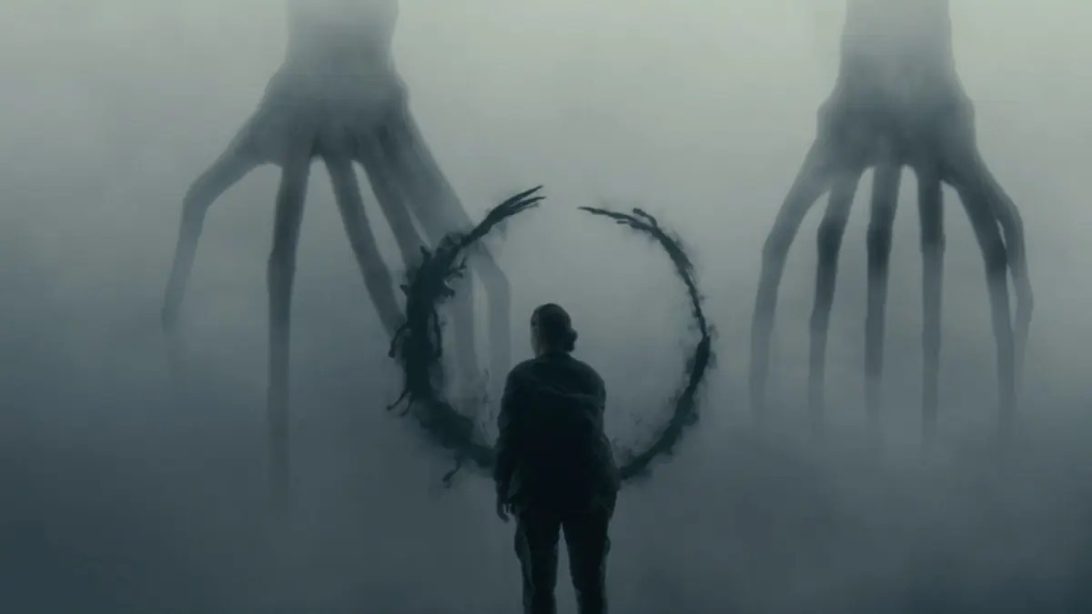 A woman stands in a misty room with two towering, squid like aliens in "Arrival"