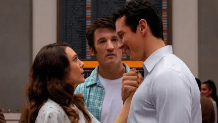 two men staring at a woman